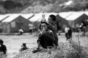 两名从八宝村跑出来的小朋友在受灾群众安置区外玩耍。晨报特派鲁甸记者
