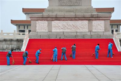 9月28日，北京，为迎接首个烈士纪念日，人民英雄纪念碑四周已铺上红地毯。图为环卫工人进行清扫保洁。