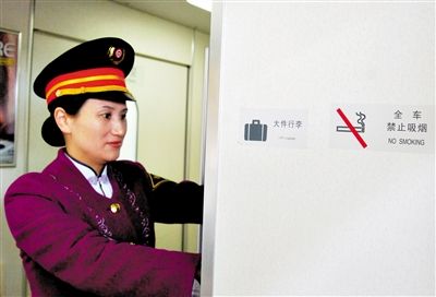 2011年1月8日，列车工作人员在贴有禁烟标志的动车上整理行李。